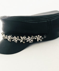 La Casquette des Saintes Ida Degliame est un modèle en cuir noir avec un bijou en strass
